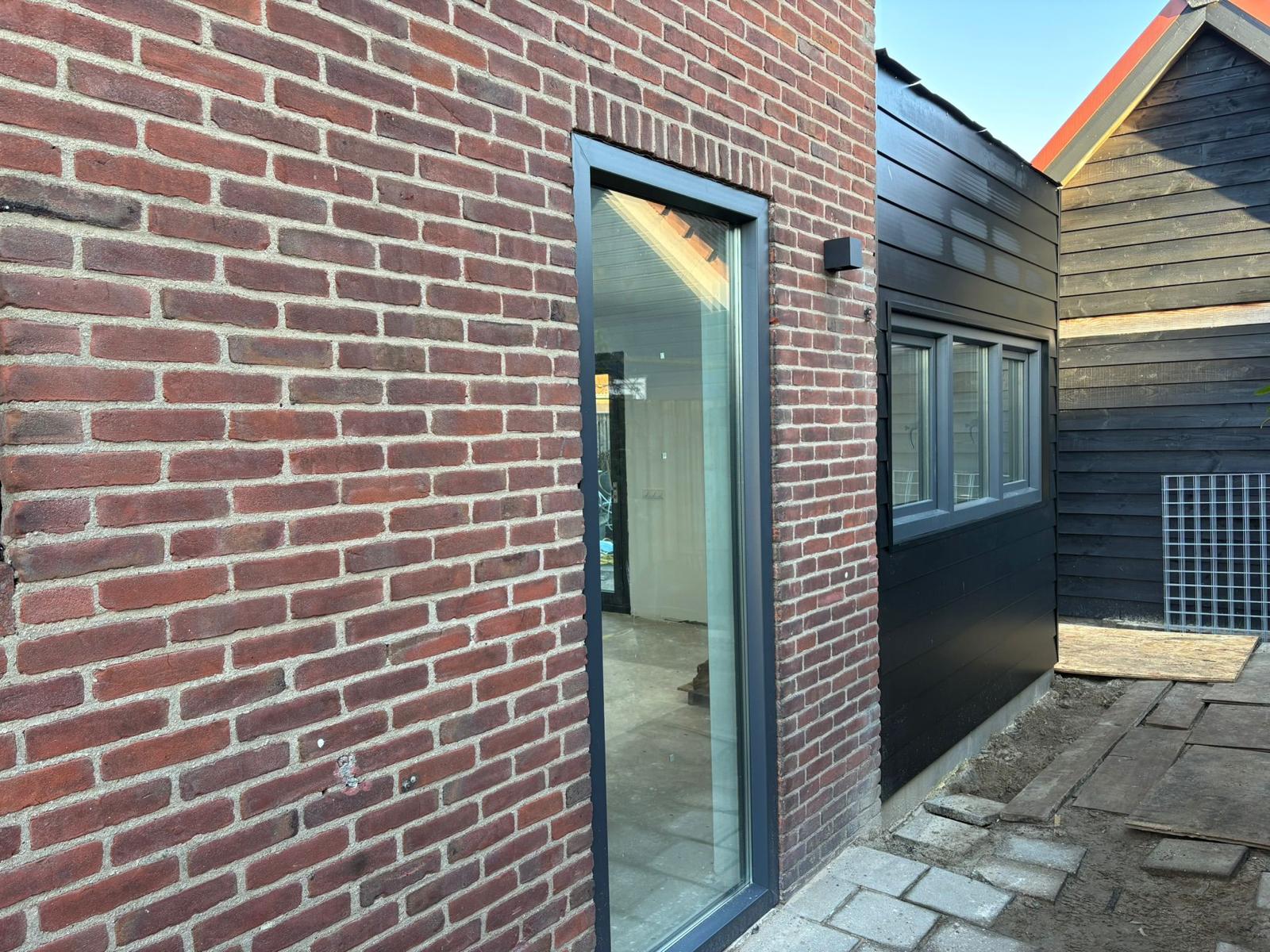 Aanbouw & uitbouw – afgeronde uitbouw met zwarte gevelbekleding